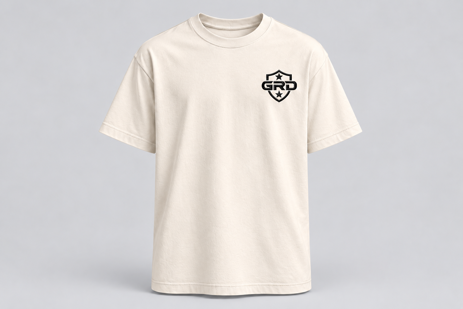 Front of the ivory GRD T-shirt with the two-star shield embroidered on the left chest